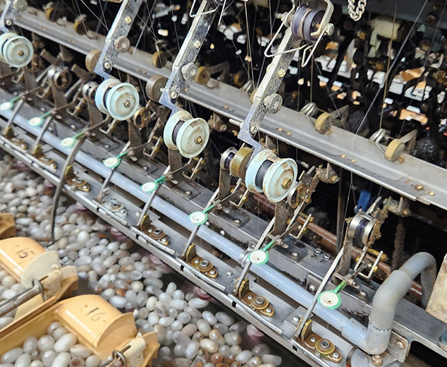 繭から機械が糸を引く様子2